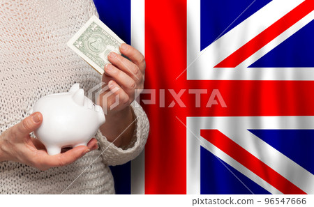 English woman with money bank on the background of UK flag. Dotations, pension fund 96547666