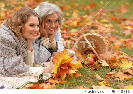 An elderly woman with her daughter lies in autumn. An elderly woman with her daughter lies in autumn. 96548818