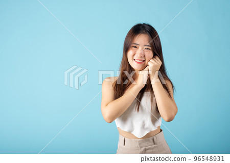 Close up woman smiling with natural makeup and healthy face, Asian young female with beauty face touching healthy facial skin studio shot isolated on blue background, Skin care and Beauty concept 96548931