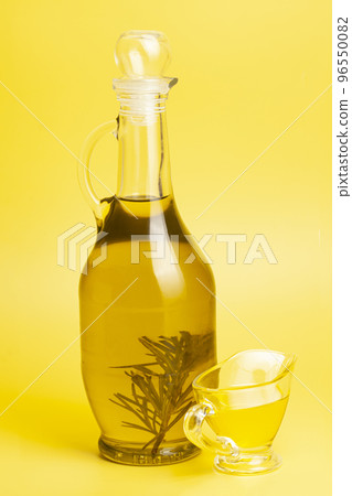 Jug with olive oil, green and black olives on yellow background. 96550082