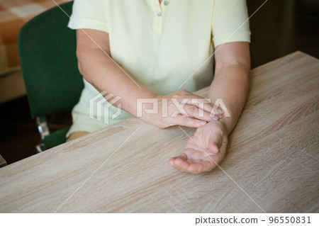 mature woman measures the pulse itself mature woman measures the pulse itself 96550831