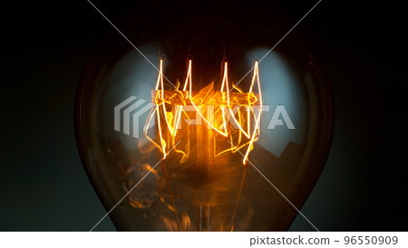 Close-up of shining vintage light bulb, dark background Close-up of shining vintage light bulb, dark background 96550909