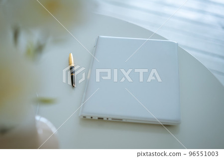 Laptop on the table and pen and flowers in a vase Laptop on the table and pen and flowers in a vase 96551003