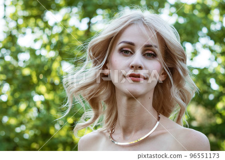 Portrait of a beautiful woman on a natural green background 96551173
