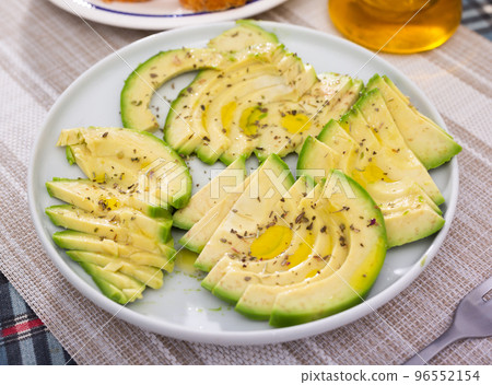 ripe avocado pulp cut into pieces sprinkled with lemon juice on a plate 96552154