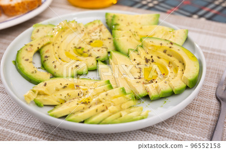 ripe avocado pulp cut into pieces sprinkled with lemon juice on a plate 96552158