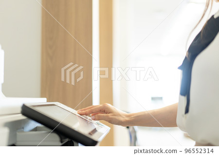 Hand of a woman who operates a copier in the office [parts cut] 96552314