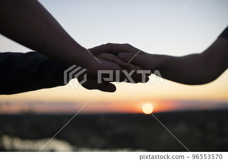 People's hands are stacked on top of each other for team development and team building against the background of the sunset sky. The concept of unity, mutual support and mutual assistance People's hands are stacked on top of each other for team development and team building against the background of the sunset sky. The concept of unity, mutual support and mutual assistance 96553570