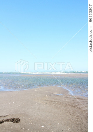 Sandy beach with traces of digging holes Sandy beach with traces of digging holes 96553807