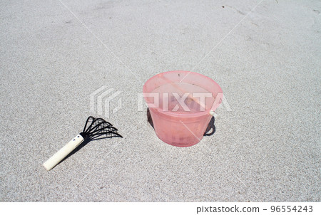 Sandy beach with bucket and bear hand Sandy beach with bucket and bear hand 96554243