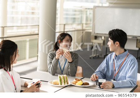 Young men and women having lunch happily 96554379