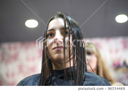 Woman in hair salon getting hair brushed Woman in hair salon getting hair brushed 96554469