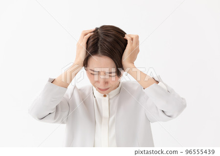 Woman holding her head white background 96555439