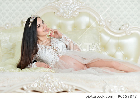 Beautiful pregnant woman posing on sofa at home 96555878