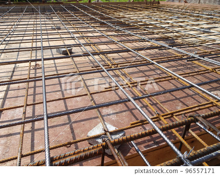 MELAKA, MALAYSIA -JULY 2, 2022: Steel reinforcement bars are arranged according to the structural engineer's design. The steels are tied together using a small steel wire. 96557171