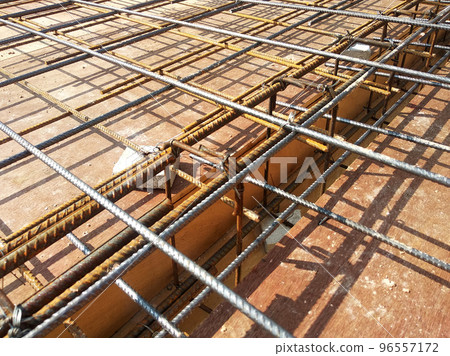 MELAKA, MALAYSIA -JULY 2, 2022: Steel reinforcement bars are arranged according to the structural engineer's design. The steels are tied together using a small steel wire. MELAKA, MALAYSIA -JULY 2, 2022: Steel reinforcement bars are arranged according to the structural engineer's design. The steels are tied together using a small steel wire. 96557172