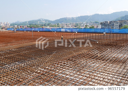 MELAKA, MALAYSIA -JULY 2, 2022: Steel reinforcement bars are arranged according to the structural engineer's design. The steels are tied together using a small steel wire. 96557179