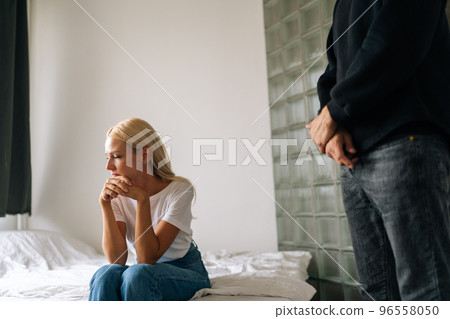 Cropped shot of frustrated blonde female tired of argument ignore unrecognizable angry husband shouting at girlfriend. Stressed wife annoyed with jealous boyfriend. Couple quarrelling yelling at home. 96558050