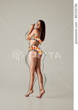 Athletic young woman showing muscles of the back Stock Photo by