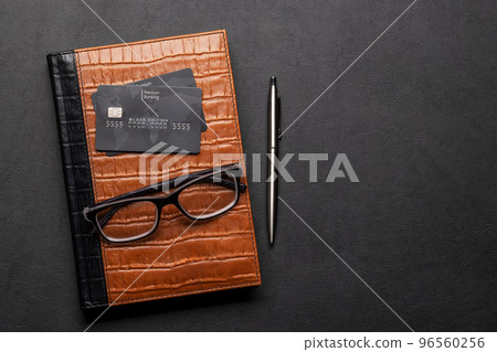 Office desk with credit card over notepad Office desk with credit card over notepad 96560256