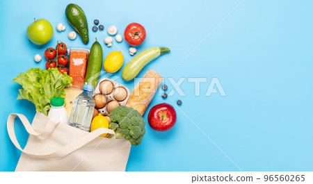 Shopping bag full of healthy food on blue 96560265