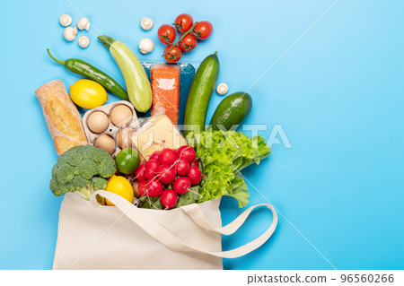 Shopping bag full of healthy food on blue 96560266