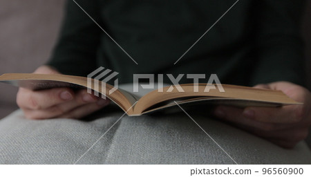 Man hand turning pages of a book, close up. Unrecognizable person hand reading a book. 96560900
