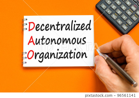 DAO decentralized autonomous organization symbol. Concept words DAO decentralized autonomous organization on white note on a beautiful orange background. Business and DAO concept. Copy space. 96561141