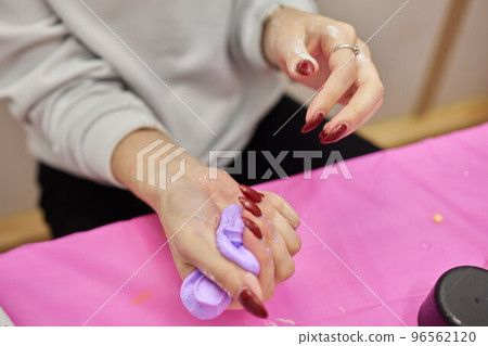 process of making slime. blue slime on a pink background. child crumples slime. 96562120