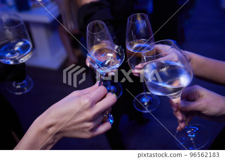 broken glass of champagne in hand Clinking glasses with alcohol and toasting, party. 96562183