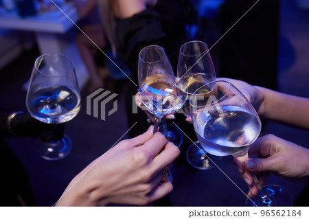 broken glass of champagne in hand Clinking glasses with alcohol and toasting, party. 96562184