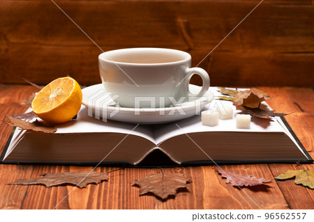 Warm drink and home relax concept. Tea cup on book Warm drink and home relax concept. Tea cup on book 96562557