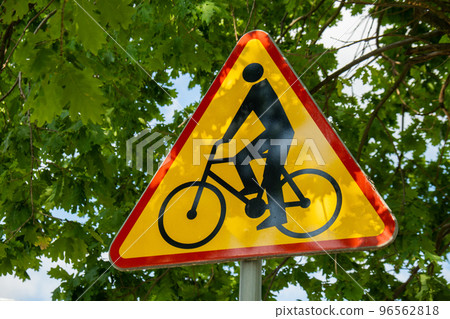 Triangle bicycle sign transit prohibited for bicycles on blurred park background. Bicyle road sign, prohibition yellow red sign 96562818