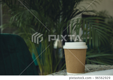 Eco recycling paper cup with coffee or tea on craft paper on table. Take away coffee to go. Copy space for text Eco recycling paper cup with coffee or tea on craft paper on table. Take away coffee to go. Copy space for text 96562929
