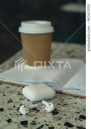 Take away coffee in craft recycling paper cup with paper notebook with wireless headphones. Mockup Coffee break. Audio healing, sound therapy wellness rituals, positive mental health habits listening 96562950