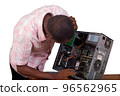 Young technician looks at and repairs a broken computer 96562965