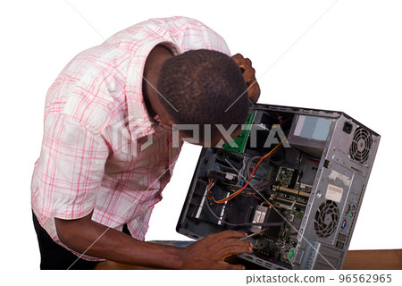 Young technician looks at and repairs a broken computer Young technician looks at and repairs a broken computer 96562965