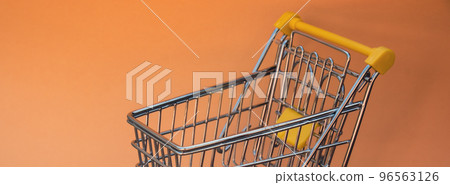 Empty shopping trolley cart on beige background. Copy space for your text. Online shopping, buy mall market shop consumer concept. Small toy supermarket grocery push cart. Food crisis. Rising food Empty shopping trolley cart on beige background. Copy space for your text. Online shopping, buy mall market shop consumer concept. Small toy supermarket grocery push cart. Food crisis. Rising food 96563126