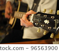 A man playing an acoustic guitar 96563900