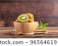 A half of kiwi in a wood bowl 96564619
