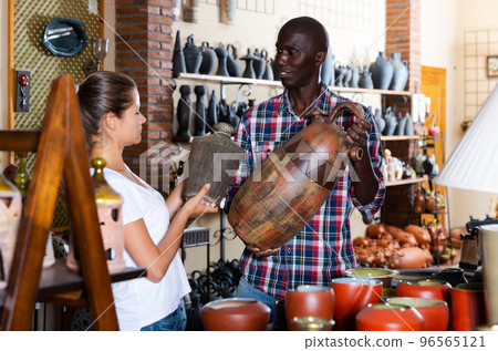African-american seller offers woman traditional handmade african pottery African-american seller offers woman traditional handmade african pottery 96565121