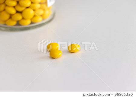 yellow pills on white table 96565380
