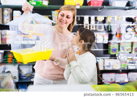 Kid girl begging her mother to buy bird cage Kid girl begging her mother to buy bird cage 96565413