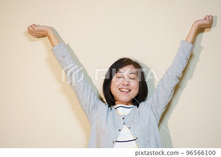 靠牆伸懶腰的中年婦女 96566100