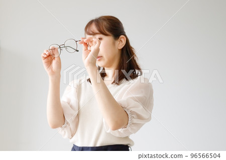 檢查眼鏡鏡片和鏡框質量的女士 96566504