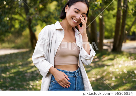 Stylish asian girl walks in park, laughs and enjoys summer weather. People and lifestyle concept 96566834