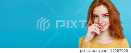 Headshot Portrait of happy ginger red hair girl with freckles smiling looking at camera. Pastel blue background. Copy Space. Headshot Portrait of happy ginger red hair girl with freckles smiling looking at camera. Pastel blue background. Copy Space. 96567006