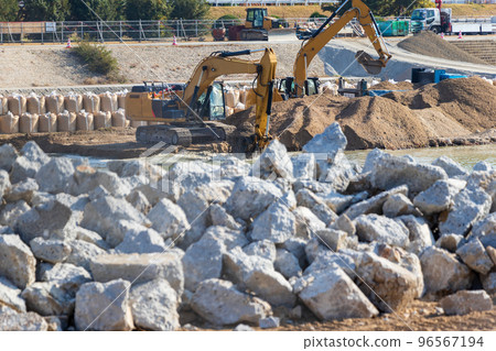 Hydraulic excavator digging soil at construction site 96567194