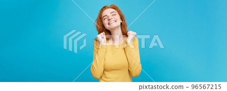 Lifestyle concept - Portrait of cheerful happy ginger red hair girl with joyful and exciting smiling to camera. Isolated on Blue Pastel Background. Copy space. 96567215