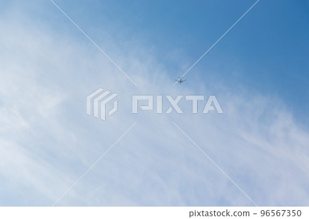 Airplane flying in the sky with thin white clouds 96567350